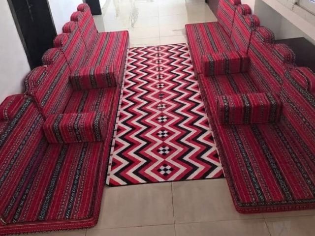 Salon arabe majlis rouge avec matelas, coussins et tapis